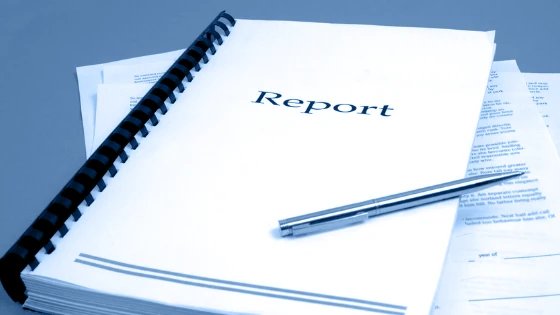 A spiral-bound report with a pen resting on its cover, tinted navy.