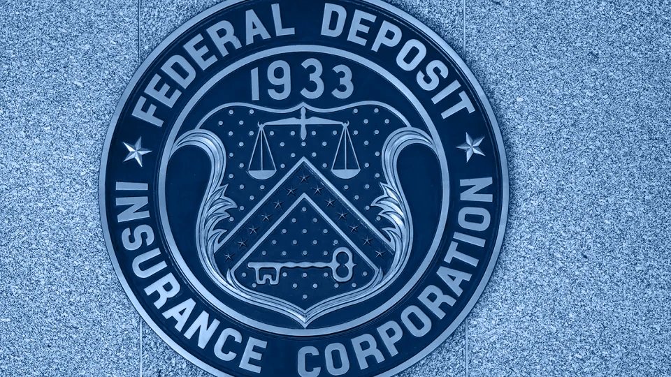 Bronze seal of the Federal Deposit Insurance Corporation on a granite wall.